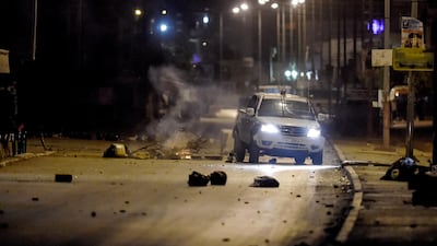 A police vehicle drives along a road blocked by protesters during clashes in the Ettadhamen city suburb on the northwestwern outskirts of Tunisia's capital Tunis amidst a wave of nightly protests in the North African country. AFP