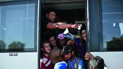 People crowd a bus provided by the Croatian government, after pushing through police lines in Tovarnik, Croatia in September. Hundreds of migrants have pushed through police lines in the eastern Croatian town of Tovarnik, with people trampling and falling on each other amid the chaos. Marko Drobnjakovic / AP