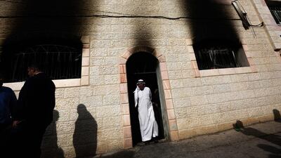 A Palestinian man stands in a doorway as he joins others in inspecting the damage at a mosque of the West Bank village of Al Mughayir after it was reportedly set on fire. Atef Safadi/EPA