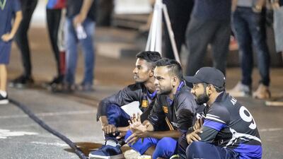 Street cricketers are enthralled by the action taking place under the floodlights.