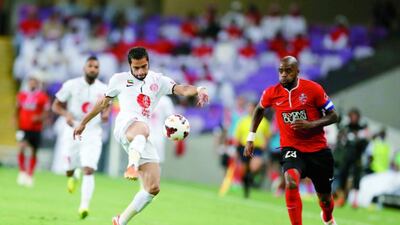 Abdulla Qasem, left, of Al Jazira holds off Grafite of Al Ahli during the Arabian Gulf Cup final at the Hazza bin Zayed Stadium in Al Ain on April 19, 2014. Courtesy Al Ittihad