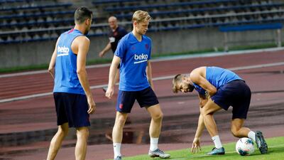 Gerard Pique, right, Frenkie de Jong, centre, and Sergio Busquets, left, during a training session at the Machida Municipal Athletic Stadium. AP Photo