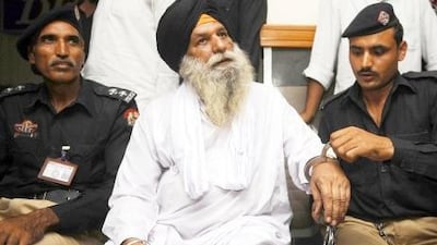 Released Indian prisoner Surjeet Singh, escorted by Pakistani security officials, sits at a waiting lounge before his departure from Pakistan to India.