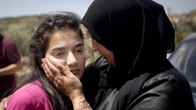 Sabha Al Wawi comforts her 12-year-old daughter, Dima, after her release from an Israeli prison, near the West Bank town of Tulkarem. Majdi Mohammed / AP Photo
