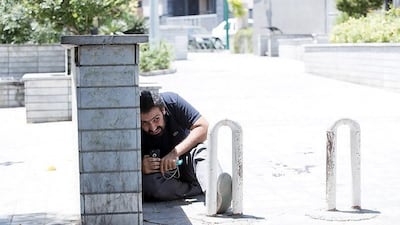 A man takes cover during an attack on the Iranian parliament in central Tehran, Iran. Tasnim News Agency / Handout via Reuters