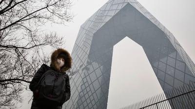 A woman wears a mask to protect against pollution as she passes the CCTV building in heavy smog on December 8, 2015 in Beijing, China. Getty Images