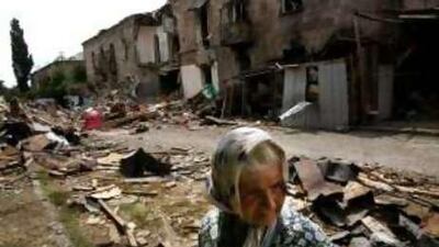 A woman stands outside bombed buildings in Gori.