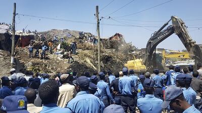 Ethiopian police officers surround the site of a landslide at rubbish dump in Addis Ababa as excavators aid rescue efforts on March 12, 2017. Elias Meseret / AP Photo