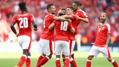 Admir Mehmedi of Switzerland is crowded out by team mates after he scored his teams first goal during the UEFA EURO 2016 Group A match between Romania and Switzerland at Parc des Princes on June 15, 2016 in Paris, France. (Photo by Clive Mason/Getty Images)
