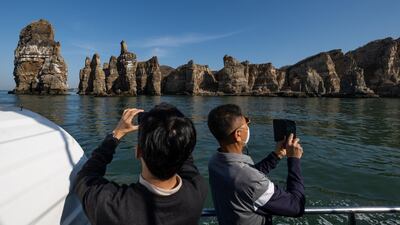 Tourists take photographs of rock formations at Baengnyeong Island, Incheon, South Korea. Even in the most optimistic scenario, visitor numbers this year would be significantly below 2019 levels. Bloomberg