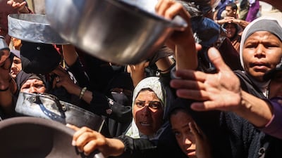 Displaced Palestinians gather to receive hot meals from a charity kitchen in Khan Younis, southern Gaza. AFP