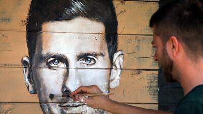 Marko Janjic, an artist, draws a portrait of Serbian tennis player Novak Djokovic on a house in Vodice, Serbia, June 25, 2020. Djokovic tested positive for the coronavirus after taking part in a tennis exhibition series he organised in Serbia and Croatia. Darko Vojinovic / AP