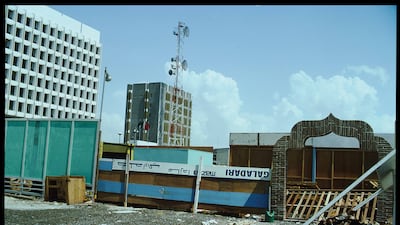 Photograph of salvaged building supplies, by Mark Harris in 1977, define and secure a construction site in Deira