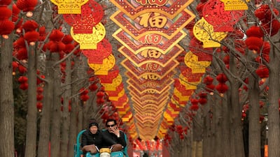 People ride a motortrike under colourful decorations at Ditan Park in Beijing. AP Photo