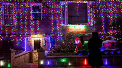 People look at a house decorated in Christmas lights in the Dyker Heights neighborhood of Brooklyn, New York, USA. Dyker Heights is know for its elaborate Christmas light displays. EPA