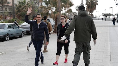 A municipal policeman, right, orders people to leave the waterfront promenade, along the Mediterranean Sea in Beirut. AP Photo