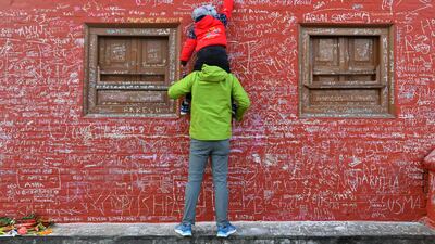 A message is chalked on to a wall at Saraswati temple, where worshippers are marking the Hindu festival of 'Basanta Panchami', in Kathmandu. AFP