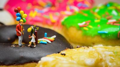 A man sells balloons on top of a colourful pile of doughnuts. Courtesy Omar Maree Humaid