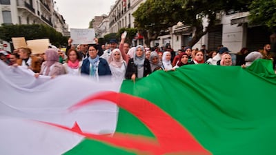 Algerians carry a giant national flag as they take part in a demonstration against president Abdelaziz Bouteflika. AFP