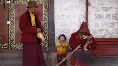 A boy puts his palms together on March 4, 2014, as he rests with his family outside Jokhang Monastery in Lhasa, Tibet autonomous region. Jacky Chen / Reuters