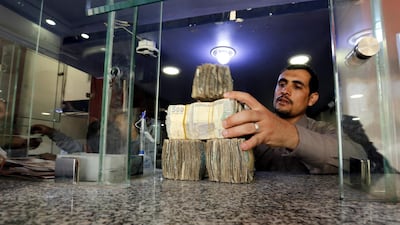 A Yemeni man holds Yemeni currency banknotes amid a continuous collapse of the Rial currency. EPA