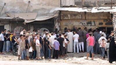 Syrian civilians queue to buy bread in the Al Marje district of Aleppo. As fighting continues to flare, many Aleppans have opposing views on which side to support.