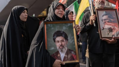 A mourner holds a portrait of Iran's supreme leader Ayatollah Mojtaba Khamenei. The new supreme leader has not been seen in public since the attack that killed his father. AFP