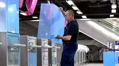 An employee installs plexiglass shields on check-in counters at Sarajevo International Airport in Bosnia. AFP