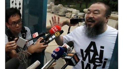 The activist and artist Ai Weiwei gestures while speaking to journalists gathered outside his home in Beijing yesterday on his return home after nearly three months in detention. Ng Han Guan / AP Photo
