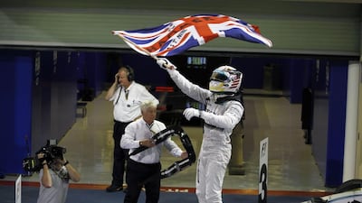 Lewis Hamilton waves the Union flag after clinching the grand prix and winning the drivers' title. Hamad I Mohammed / Reuters