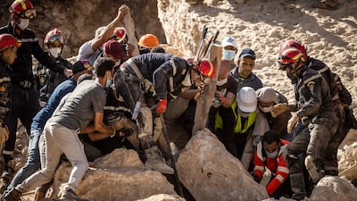Rescuers use a metal bar and a wooden beam to search for a victim amid the rubble of a destroyed house in the earthquake- hit village of Imi N'Tala near Amizmiz on September 13, 2023. Rescue teams stepped up on September 13 a massive effort in devastated Moroccan mountain villages as chances fade for finding survivors from last week's earthquake which killed 2,900 people and left many homeless. (Photo by FADEL SENNA / AFP)