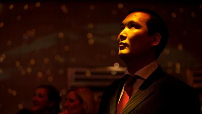 A man watchs a fashion show at the launch party.