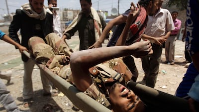Anti-government protestors carry a wounded defected soldier from the site of clashes with security forces to a field hospital in Sanaa, Yemen, on September 19, 2011. Pro-regime forces, including snipers picking off protesters from rooftops, killed severa???