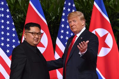 US President Donald Trump (R) gestures as he meets with North Korea's leader Kim Jong Un (L) at the start of their historic US-North Korea summit, at the Capella Hotel on Sentosa island in Singapore on June 12, 2018. Donald Trump and Kim Jong Un have become on June 12 the first sitting US and North Korean leaders to meet, shake hands and negotiate to end a decades-old nuclear stand-off. / AFP / SAUL LOEB