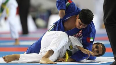 Ali Abdulrahim Alharmoodi, top, overtook his opponent, Faisal Mutaab Alqahtani in their match-up during the Kids Super Cup jiu-jitsu competition held at FGB Arena at Zayed Sports City on Saturday, November 29, 2014. Over 1,500 kids participated. Delores Johnson / The National