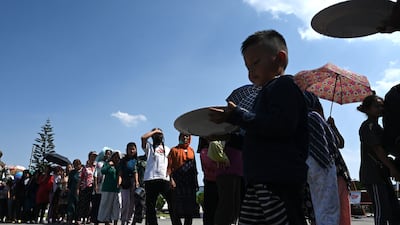 People queue for food distributed by the Indian army at Imphal Airport in Manipur. AFP