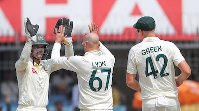 Australia wicketkeeper Alex Carey, left, celebrates with Nathan Lyon after the spinner's dismissal of India captain captain Rohit Sharma for 12. AP
