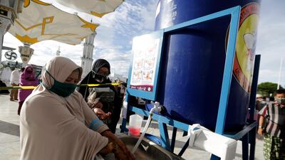Muslim devotees wash their hand before attending Eid Al Adha prayers at Baiturrahman Grand Mosque, Banda Aceh, Indonesia. EPA
