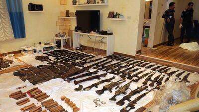 Kuwaiti police stand next to the weapons seized on Thursday. AFP PHOTO / HO / KUNA