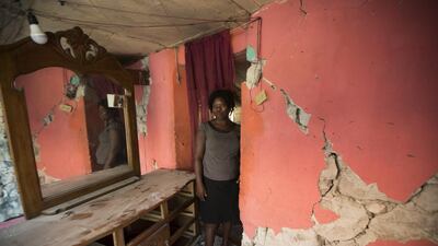 A woman walks amid the debris of her house that was destroyed in Gros Morne. EPA