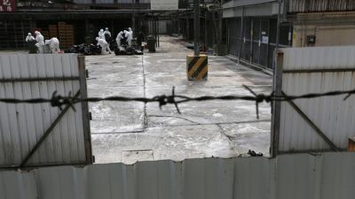 Health workers in full protective gear slaughter chickens by using carbon dioxide. (AP Photo/Vincent Yu)