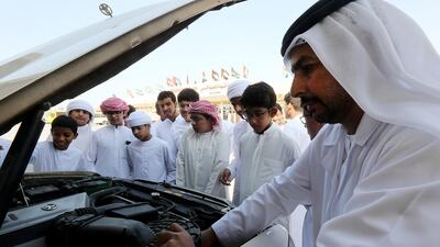 Social worker Yaqoob Mohammed Al Hammadi teaches school students how to fix cars and regular maintenance on as part of a behavioral correction at a school in Sharjah. Satish Kumar / The National