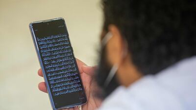 A pilgrim reads passages of the Quran from his phone. AFP