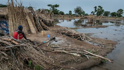 Nyibol Arop, 27, a mother of five, boils her morning tea by the stagnant water that threatens her shelter, in Majak Awar village, Northern Bahr El Ghazal.