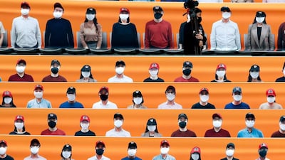A TV cameraman walks through the spectators' seating which are covered with pictures of fans, before the start of a regular season baseball game between Hanwha Eagles and SK Wyverns in Incheon, South Korea. AP