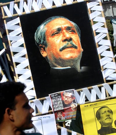 In this file photo taken on August 15, 2006 a Bangladeshi man looks at portraits of the country's fouding father Sheikh Mujibur Rahman during a six hour nation wide general strike in Dhaka. AFP