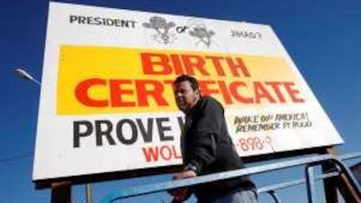 David Lee puts the final touches on a sign questioning whether the US president Barack Obama is a US citizen in suburban Denver, Colorado.