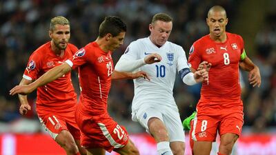 Egland's Wayne Rooney charges through Switzerland players during their Euro 2016 qualifying contest on Tuesday. Glyn Kirk / AFP