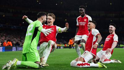 Arsenal players rush to celebrate with goalkeeper David Raya after his penalty save on Porto's Gelano clinched victory in the Champions League last 16 at Emirates Stadium. AFP