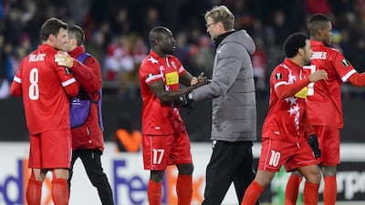 epa05064197 Liverpool's manager Juergen Klopp, (3-R) shakes hand with Sion's Jagne Pa Modou (C) as Sion's soccer players celebrates the qualification during the UEFA Europa League group B soccer match between FC Sion and FC Liverpool at the Tourbillon stadium in Sion, Switzerland, 10 December 2015. EPA/JEAN-CHRISTOPHE BOTT